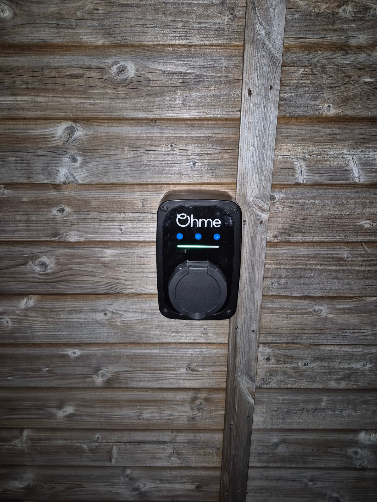 Ohme home EV charger installed on a timber clad wall
